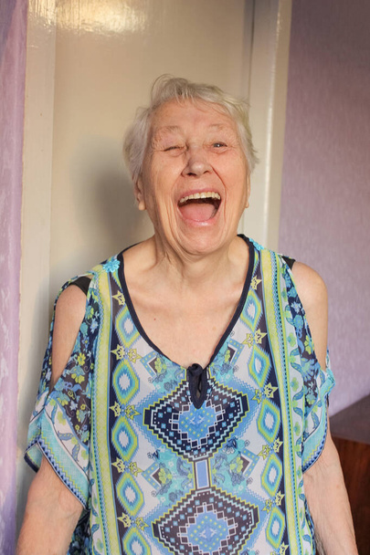 A portré egy vidám mosolygós idős nő odahaza háttér - Fotó, kép