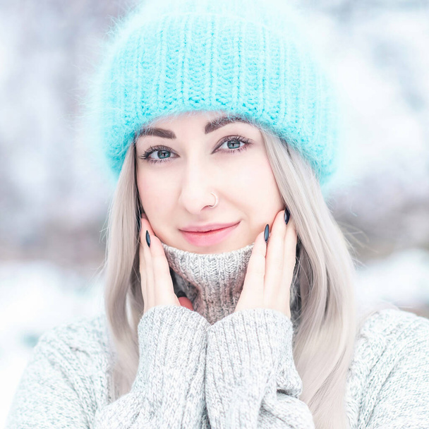 Close up photo of  young woman European appearance in blue hat with beautiful eyes and ring in the nose - Photo, Image