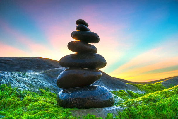 Stacked Pebbles art on mossy rocks welcomes beautiful new day - Photo, Image