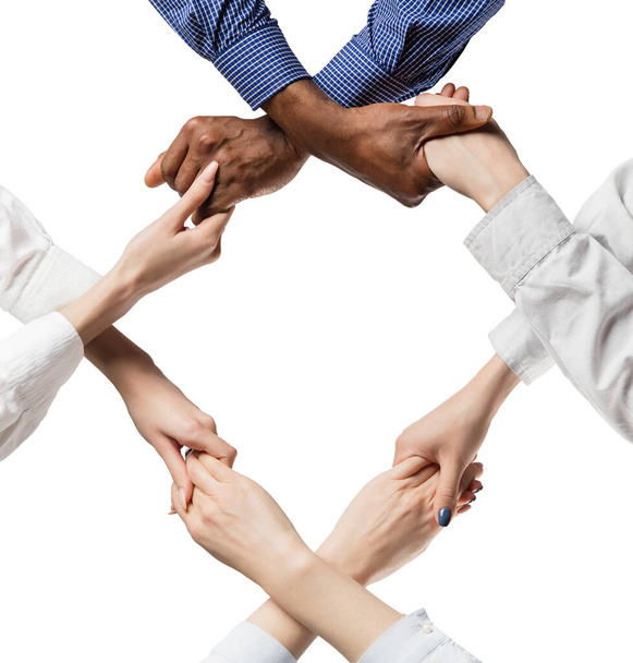 Ομάδα νέων επιχειρηματιών που κρατούν ο ένας το χέρι του άλλου. Έννοια ενότητας. - Φωτογραφία, εικόνα