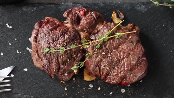 primer plano de carne de res recién asada carne de res con especias en plato de piedra negro, vista superior zoom en - Imágenes, Vídeo