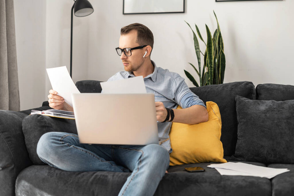 A freelancer with a laptop doing paperwork - Фото, зображення