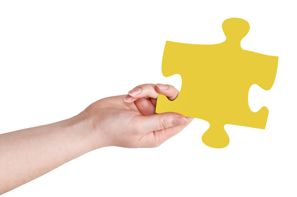 female hand with yellow puzzle piece - Photo, Image