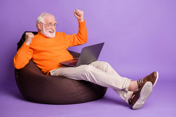 Full size profile portrait of delighted man fists up celebrate wear pants shoes isolated on purple color background - Foto, afbeelding