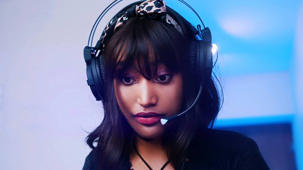 Retrato de una joven americana negra con auriculares trabajando desde casa - Foto, imagen