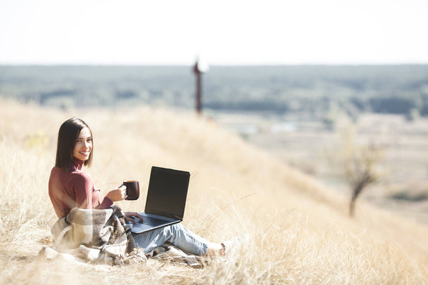 Woman woking outdoors. Remote work on camping. Female typing on pc. - Photo, Image