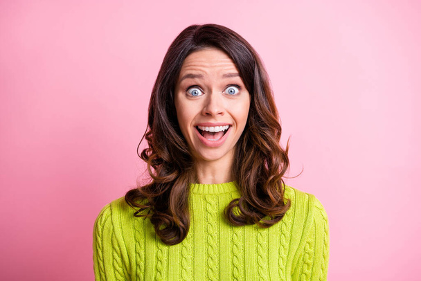 Photo of funny crazy wavy young lady wear green sweater open mouth big eyes isolated pastel pink color background - 写真・画像