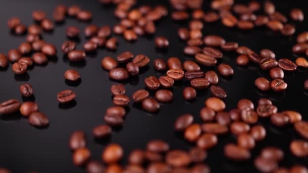 Жареный кофе в зернах на черном фоне - Кадры, видео