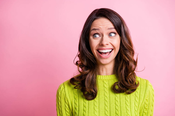 Photo of excited shocked girl open mouth look side empty space wear green sweater isolated pink color background - Foto, Imagem