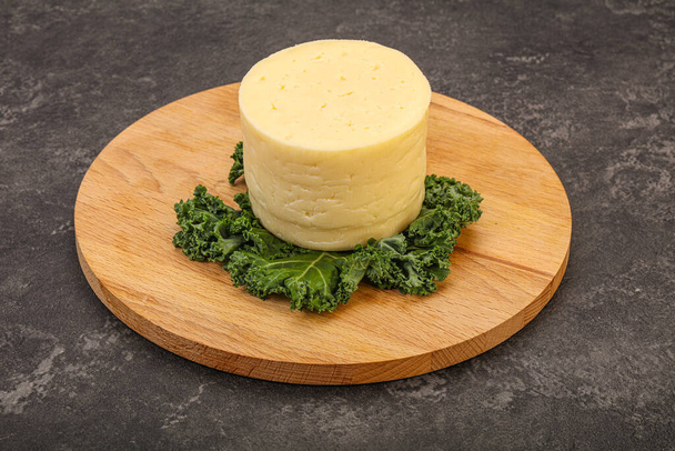 Желтый круглый кусочек мягкого сыра - Фото, изображение
