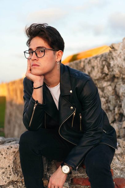 Egy spanyolajkú férfi szemüveggel a korláton a szabadban. - Fotó, kép