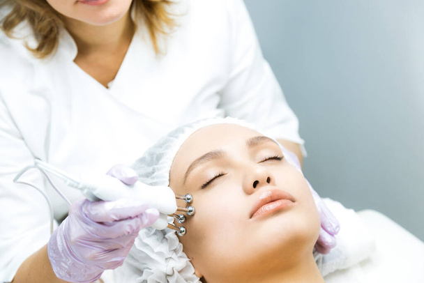 Uma mulher num encontro de esteticistas. Levantamento facial não cirúrgico. terapia facial microatual - Foto, Imagem