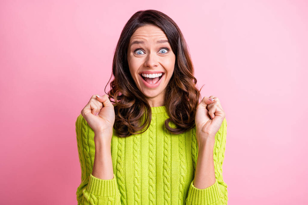 Photo of funky amazed young lady open mouth raise fists wear green sweater isolated pink color background - Fotografie, Obrázek