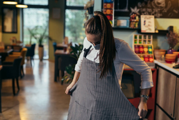 waitress preparing for work in restaurant or cafe - Photo, Image