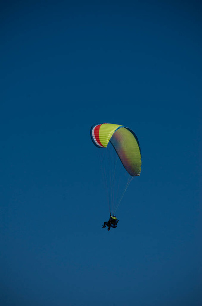 parapente sozinho no céu azul sem qualquer nuvem, voando. imagem vertical com espaço de cópia - Foto, Imagem