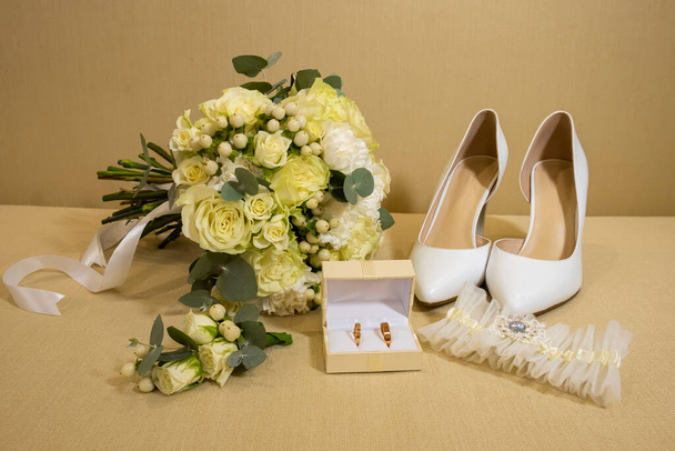 結婚式の詳細。花嫁のアクセサリー。花束、靴、ガーター、箱の中のリング。黄緑色. - 写真・画像