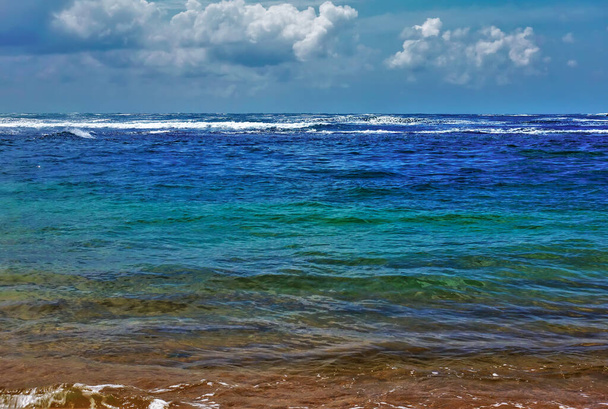 Indiai-óceáni festékpaletta. Aquamarin, türkiz, kék víz és a hullámok fehér habja. Cumulus felhők vannak az azúrkék égen. Srí Lanka. - Fotó, kép