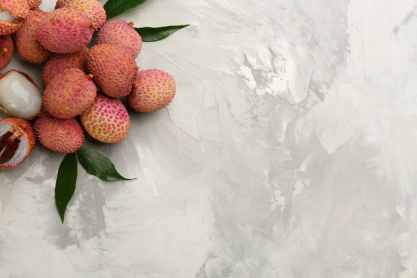 Frutas de lichia maduras frescas em mesa cinza claro, flat lay. Espaço para texto - Foto, Imagem