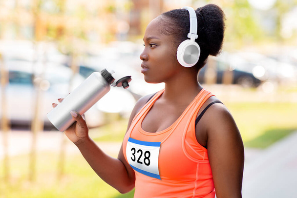 african female marathon runner drinking water - Valokuva, kuva