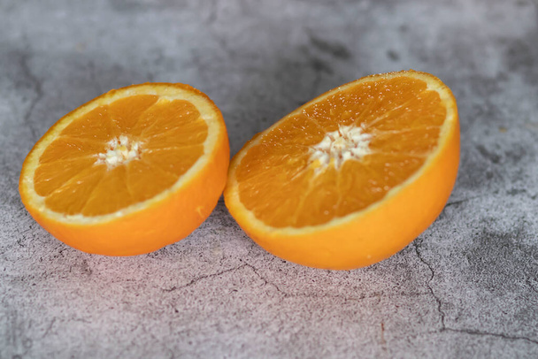 De oranje helften liggen op tafel. Op een grijze en witte achtergrond. - Foto, afbeelding