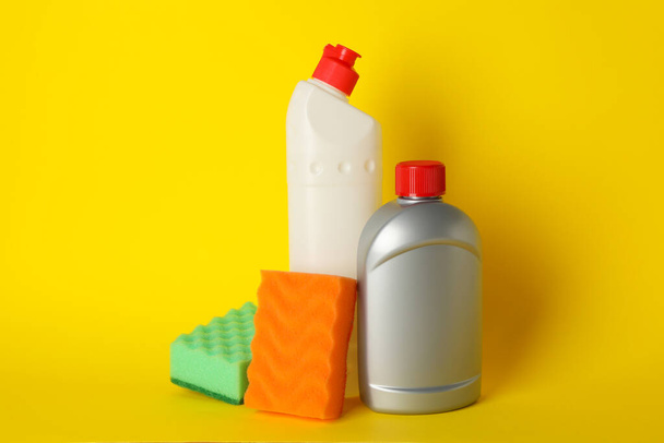 Detergents and sponges on yellow background, space for text - Foto, afbeelding