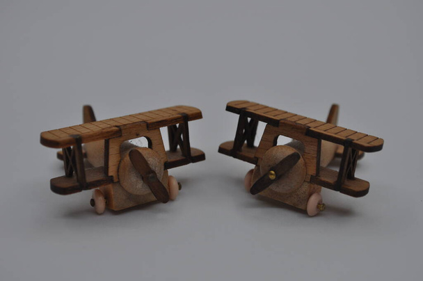 Κοντινές δημιουργικές λήψεις μικρών μοντέλων ξύλινων αεροπλάνων χειροποίητων από ξύλο, διαστάσεων περίπου 3cm X 2cm - Φωτογραφία, εικόνα