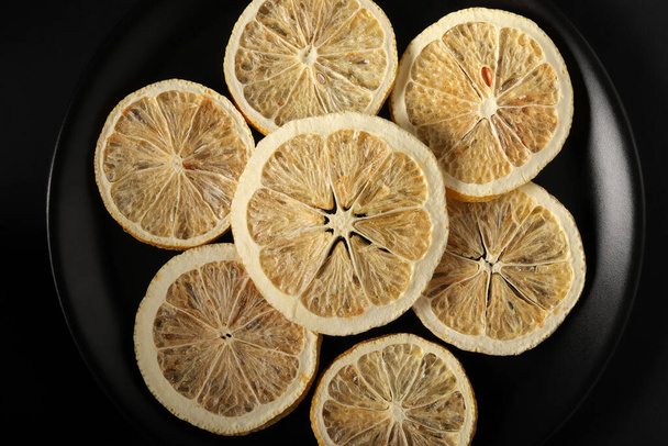Dried lemon slices in a black plate - Photo, Image
