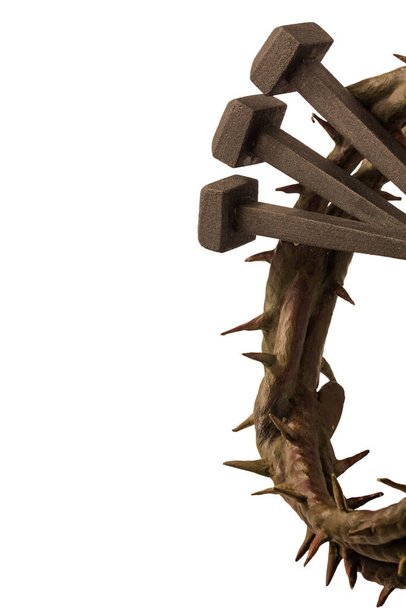 Jesus Christ crown of thorns and nails on a white background. Focus is on part of the nails. - Photo, Image