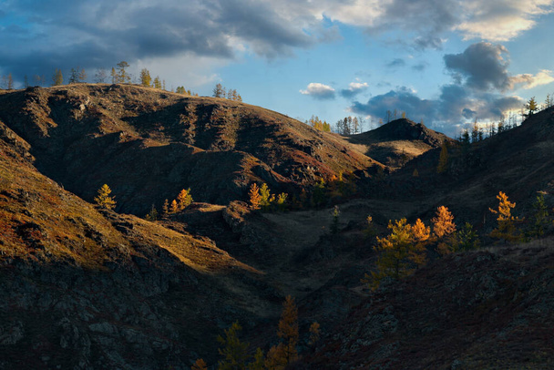 Rusia. Mountain Altai. Gráficos expresivos de la luz del sol de otoño en las rocas de las cadenas montañosas. - Foto, Imagen