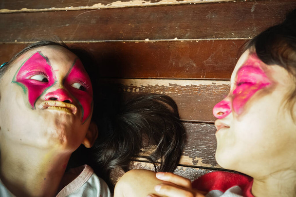 Αστεία έκφραση των παιδιών της Νοτιοανατολικής Ασίας συνθέτουν το πρόσωπό τους με χαρακτήρα κλόουν. - Φωτογραφία, εικόνα