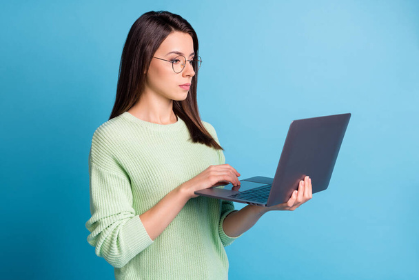 Photo of focused smart girl expert search statistics on laptop wear jumper isolated over blue color background - Fotografie, Obrázek