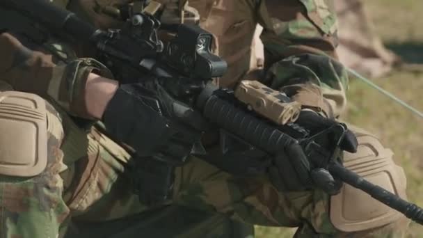 Inclinando-up filmagem de oficial de inteligência caucasiano barbudo em camuflagem uniforme segurando rifle sniper - Filmagem, Vídeo