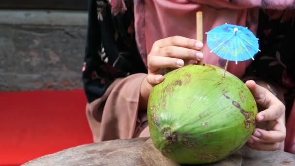  donne che bevono succo di cocco in una noce di cocco fresca sul tavolo  - Filmati, video