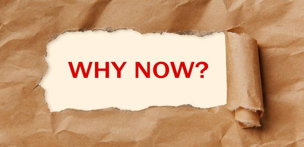 Motivation encouragement quote. Text - WHY NOW - appearing behind torn brown paper. - Photo, Image