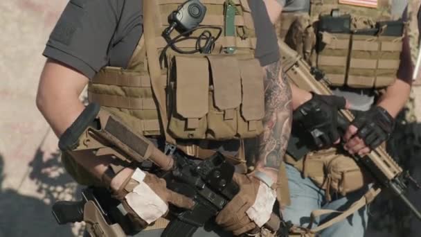 Aufklappbares Porträt seriöser Männer mit taktischen Westen und Sonnenbrille, die in die Kamera blicken und Scharfschützengewehre in militärischer Einheit draußen halten - Filmmaterial, Video