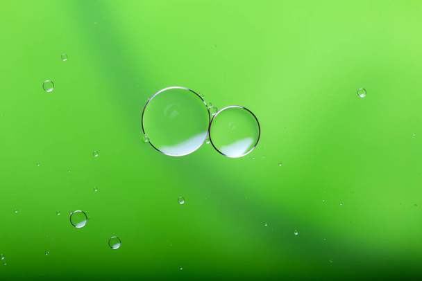 Öljy sekoitetaan veteen, abstrakti värikäs tausta. Vihreä tausta ja rakenne. - Valokuva, kuva