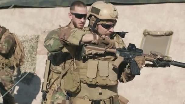 Seguimiento de disparo de grupo de oficiales de inteligencia en ropa de camuflaje preparándose para la operación militar, cargando armas en el campo - Metraje, vídeo