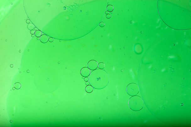 Olie gemengd met water, abstracte kleurrijke achtergrond. Groene achtergrond en textuur. - Foto, afbeelding