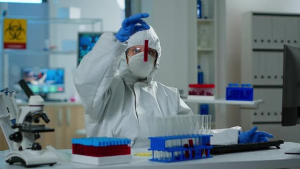 Investigador en bata que sostiene tubos de ensayo con muestra de sangre - Metraje, vídeo