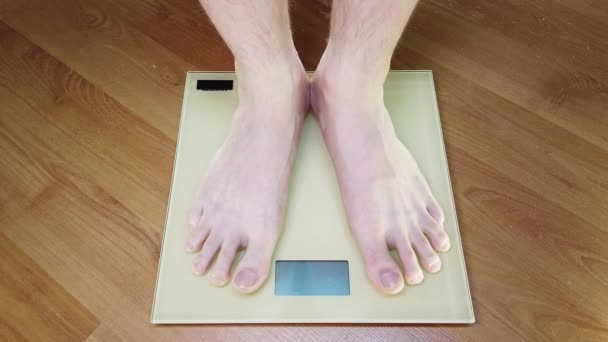 Man checking his weight. Legs on the scales. - Footage, Video