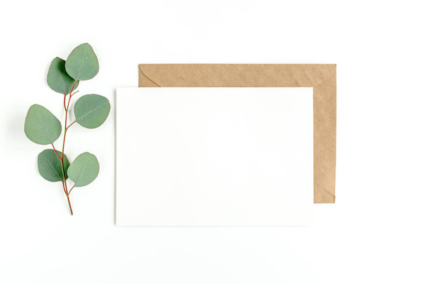 Mockup invitation, blank greeting card and green leaves eucalyptus. Flat lay, top view. - Photo, image
