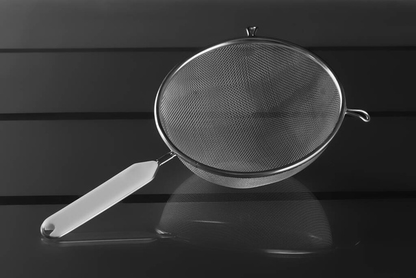Metallic strainer with plastic handle, a modern kitchen utensil - Photo, Image