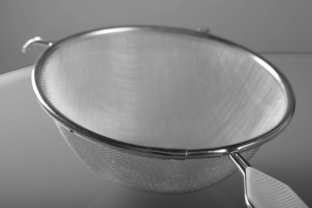 Fechar uo de filtro metálico com alça de plástico, um utensílio de cozinha moderna - Foto, Imagem