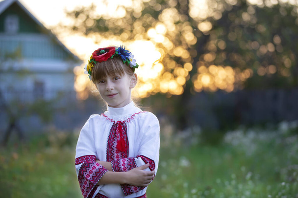 ボケの背景に民族衣装の美しい小さなスラブ人の少女。ウクライナ人またはベラルーシ人の子供. - 写真・画像