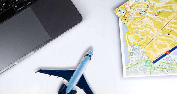 tourist travel concept, Macbook with map and airplane toy, holiday season vacation. Apple iPhone. Apple is a multinational technology company. Moscow, Russia - July 27, 2020 - Zdjęcie, obraz