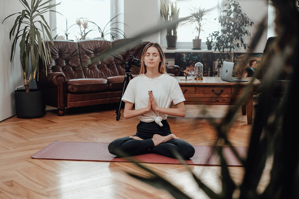 Fitness žena medituje v klidném a moderním obývacím pokoji - Fotografie, Obrázek
