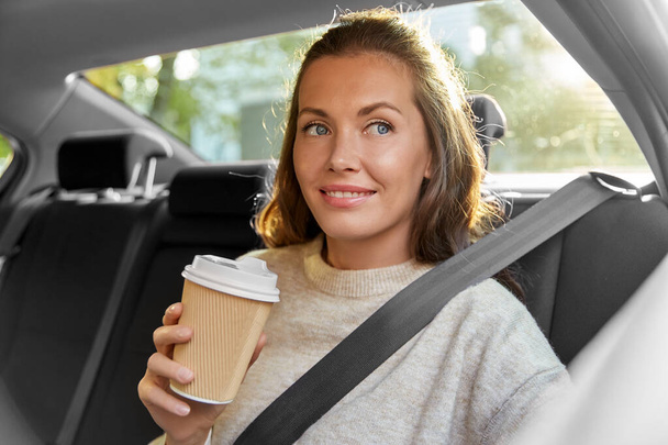 smiling woman or passenger drinking coffee in car - Photo, Image