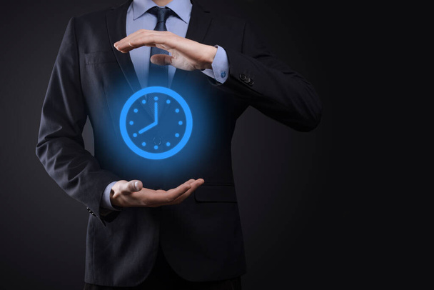 Az üzletember kézben tartja az óra ikonját nyíllal. A munka gyors végrehajtása.Üzleti idő menedzsment és az üzleti idő a pénz fogalmak. - Fotó, kép