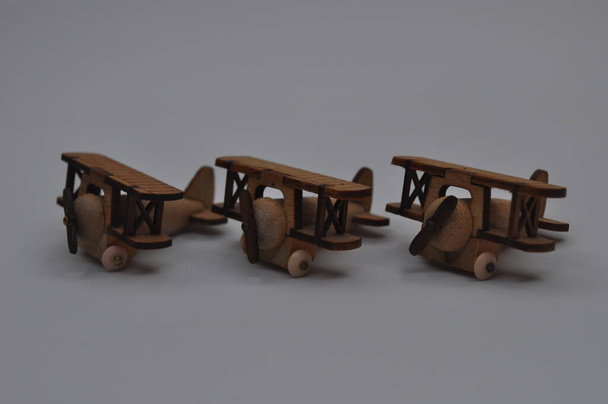 Kreative Nahaufnahmen von kleinen hölzernen Flugzeugmodellen aus Holz, ca. 3cm x 2cm groß - Foto, Bild