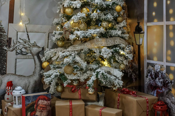 Fotoğraf stüdyosunda Noel süslemesi. Altın topları ve hediye kutusuyla güzel bir Noel ağacı - Fotoğraf, Görsel